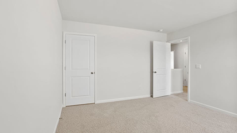Bedroom with carpet and window.