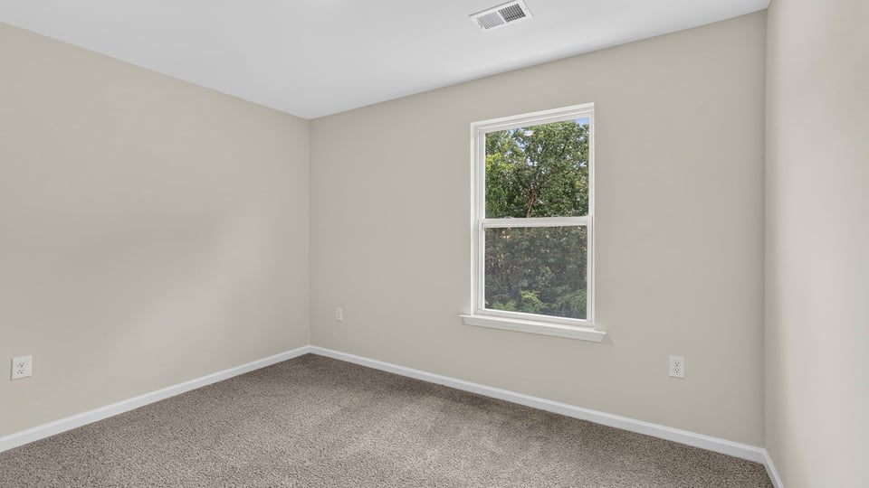 Bedroom with carpet and window.