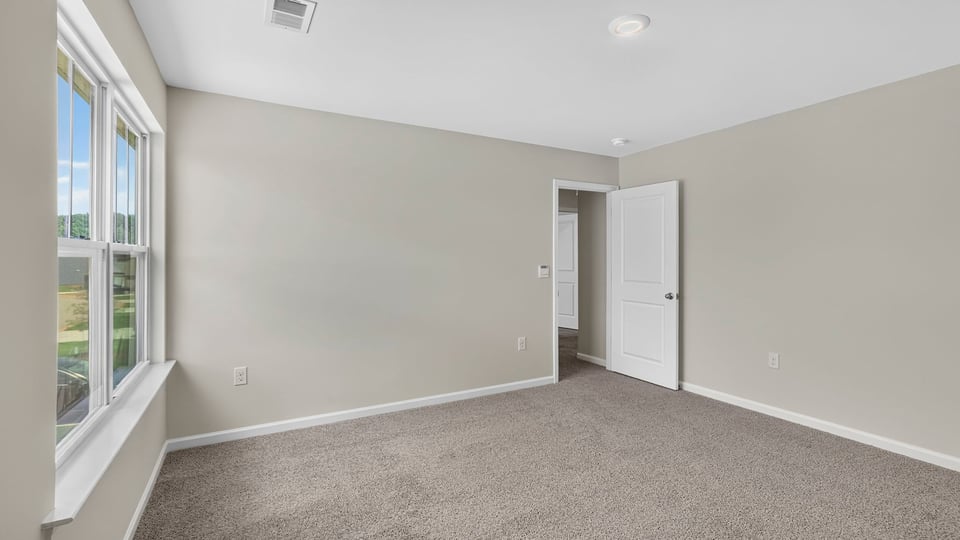 Bedroom with carpet and window.