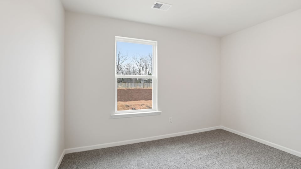 Bedroom with carpet and window.