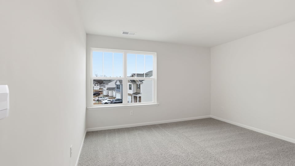 Bedroom with carpet and window.