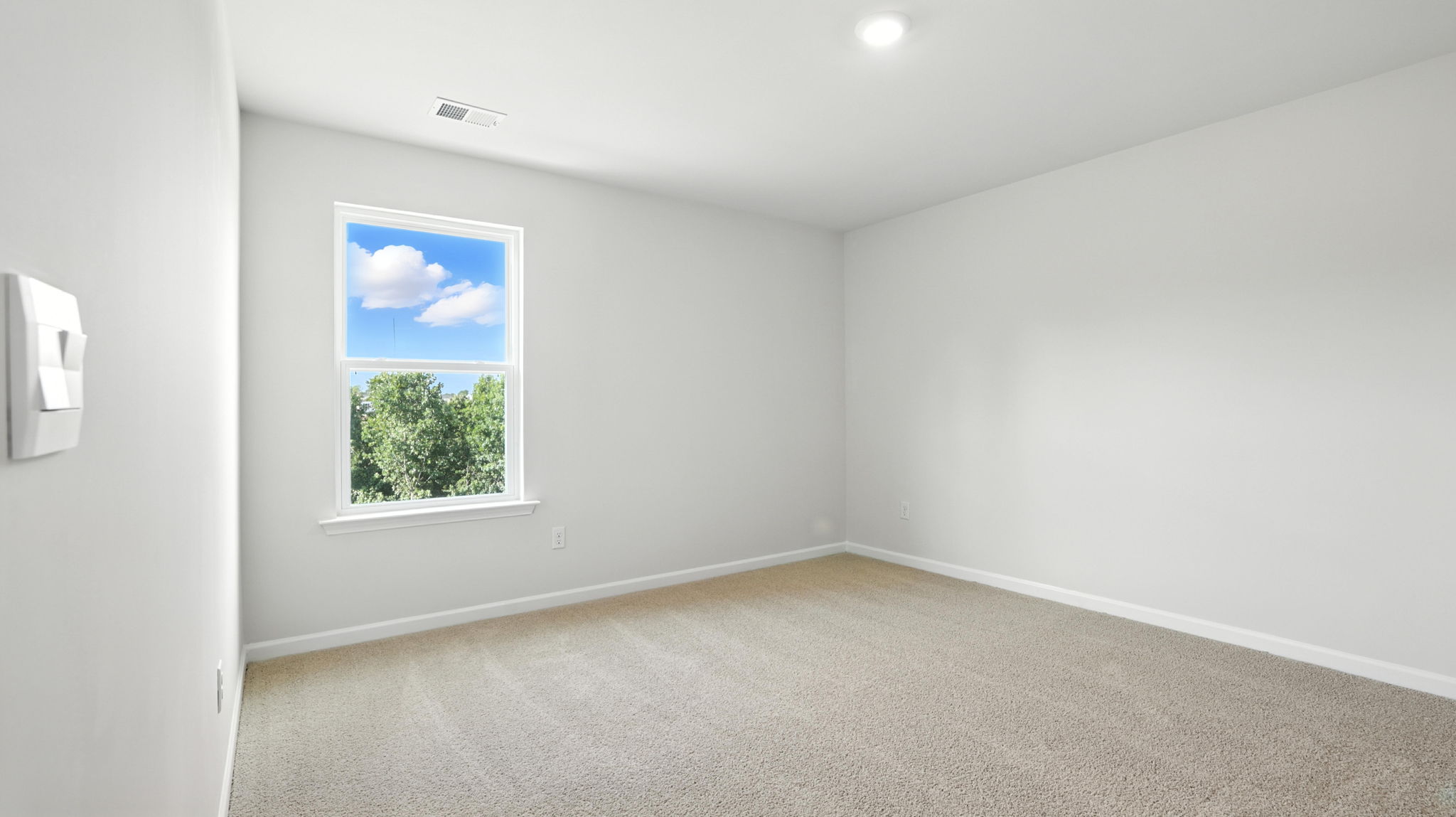 Bedroom with carpet and window.