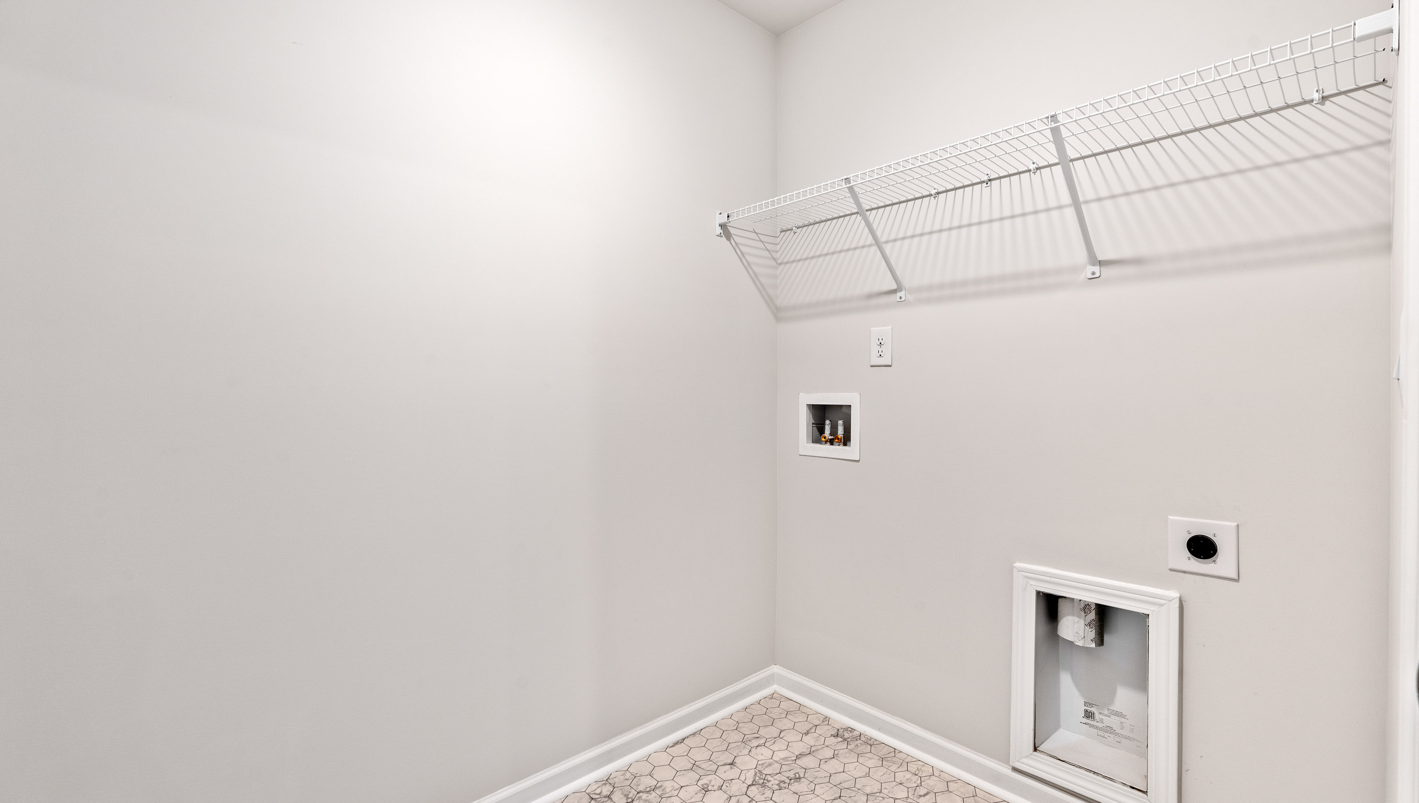 Walk in laundry with hanging shelves.