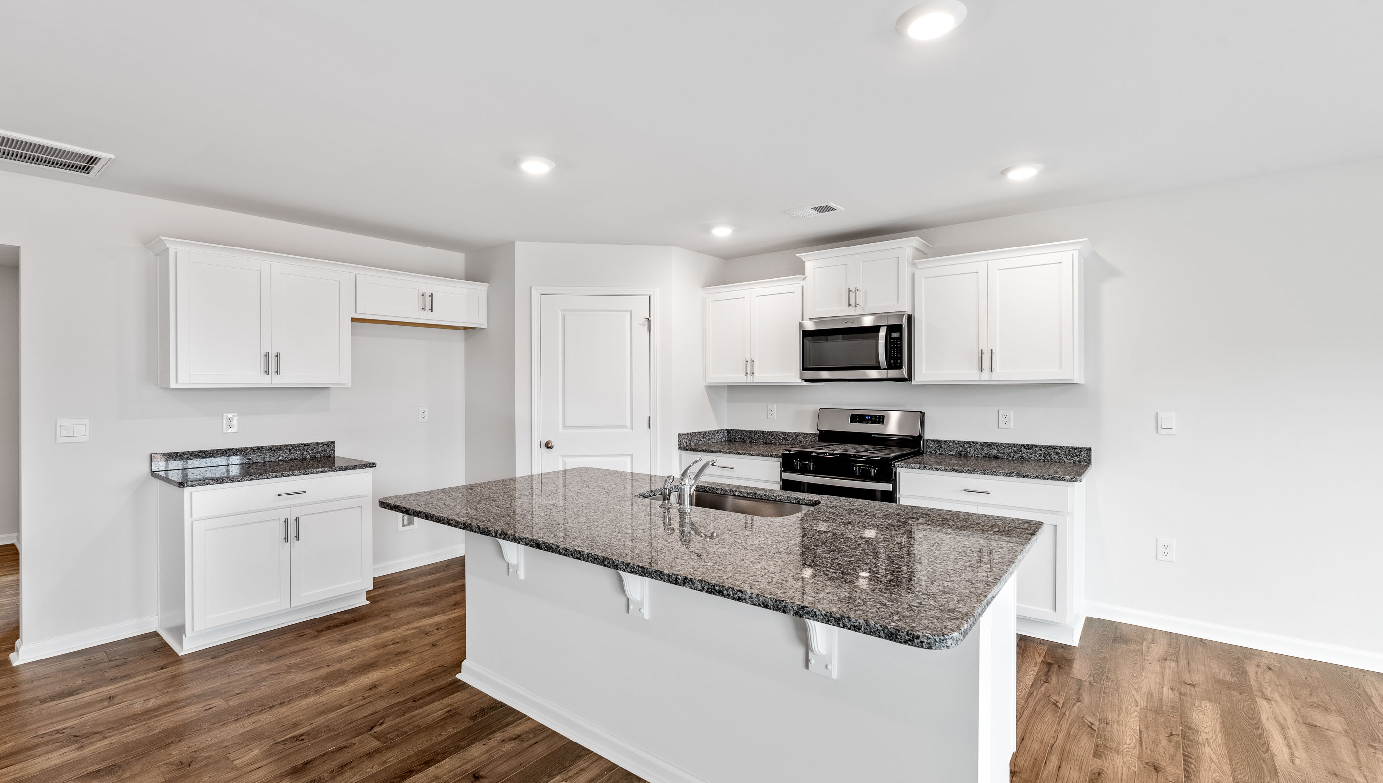 Kitchen and island with granite countertops.