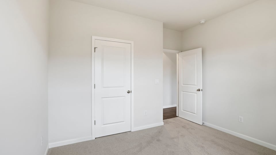Bedroom with carpet and windows.