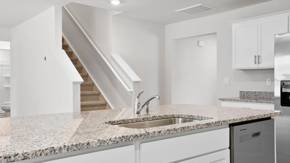 Kitchen area with granite island and stainless-steel appliances.