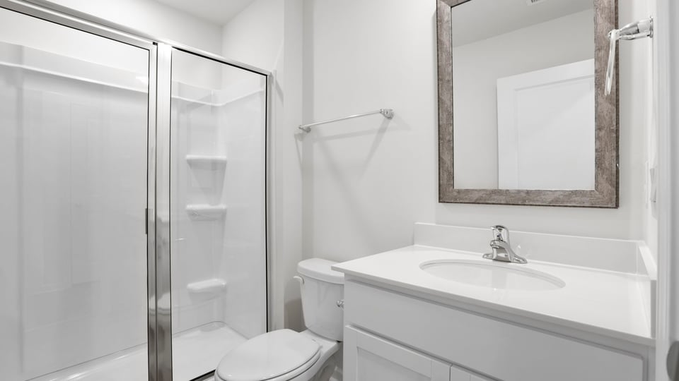 First floor bathroom with vanity and walk in shower.