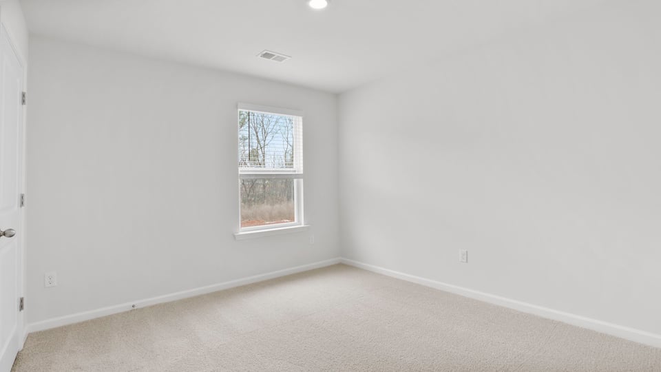 Bedroom with carpet and window.