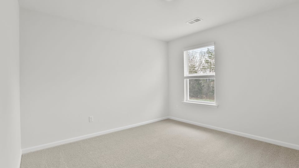 Bedroom with carpet and window.