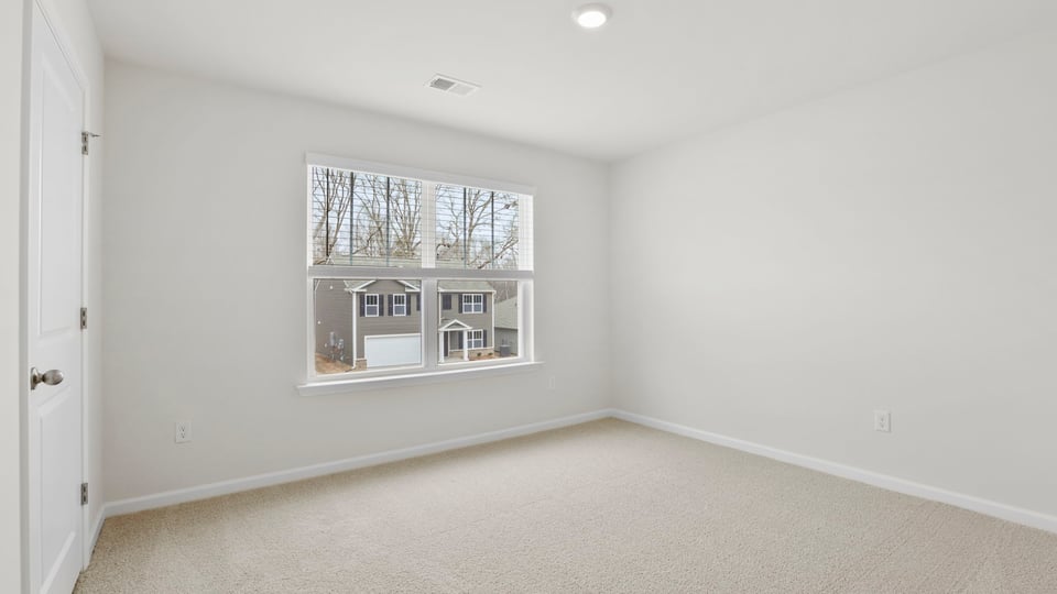 Bedroom with carpet and window.