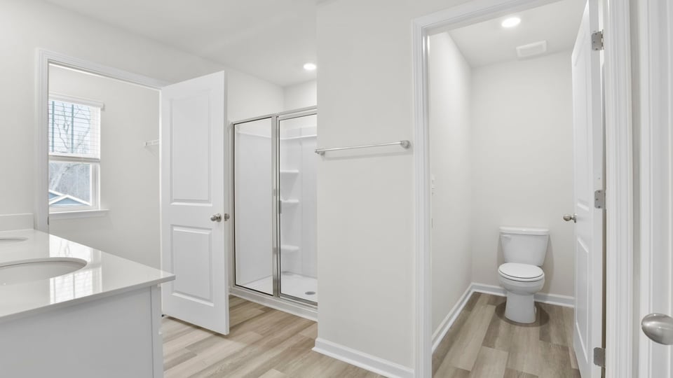 Primary bathroom with window and walk in shower.