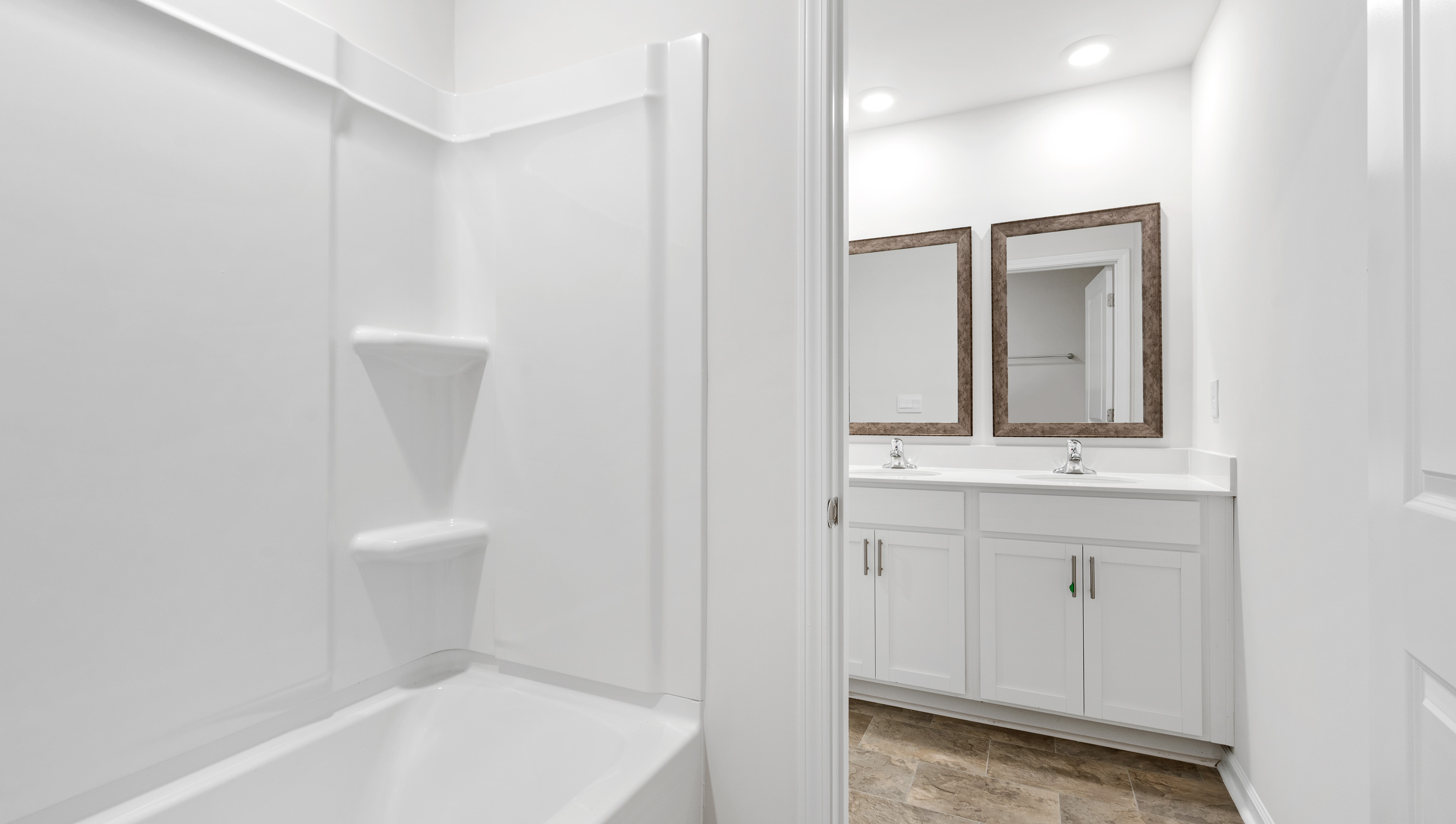 Bathrooom with vanities and tub.