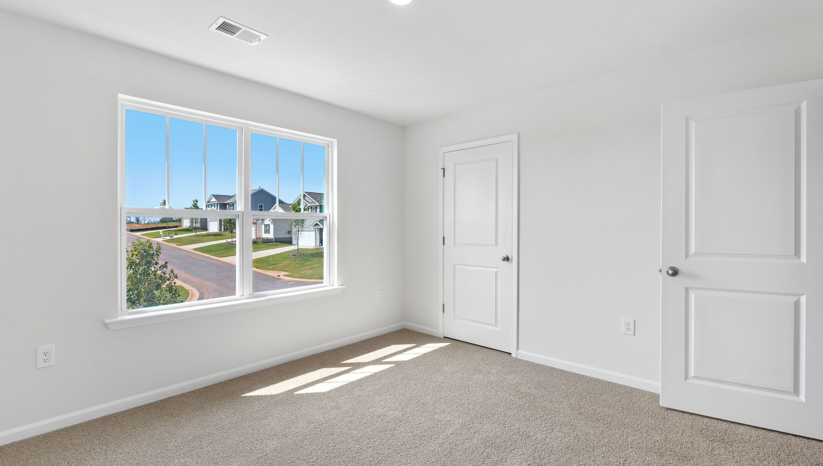 Bedroom with carpet and windows.
