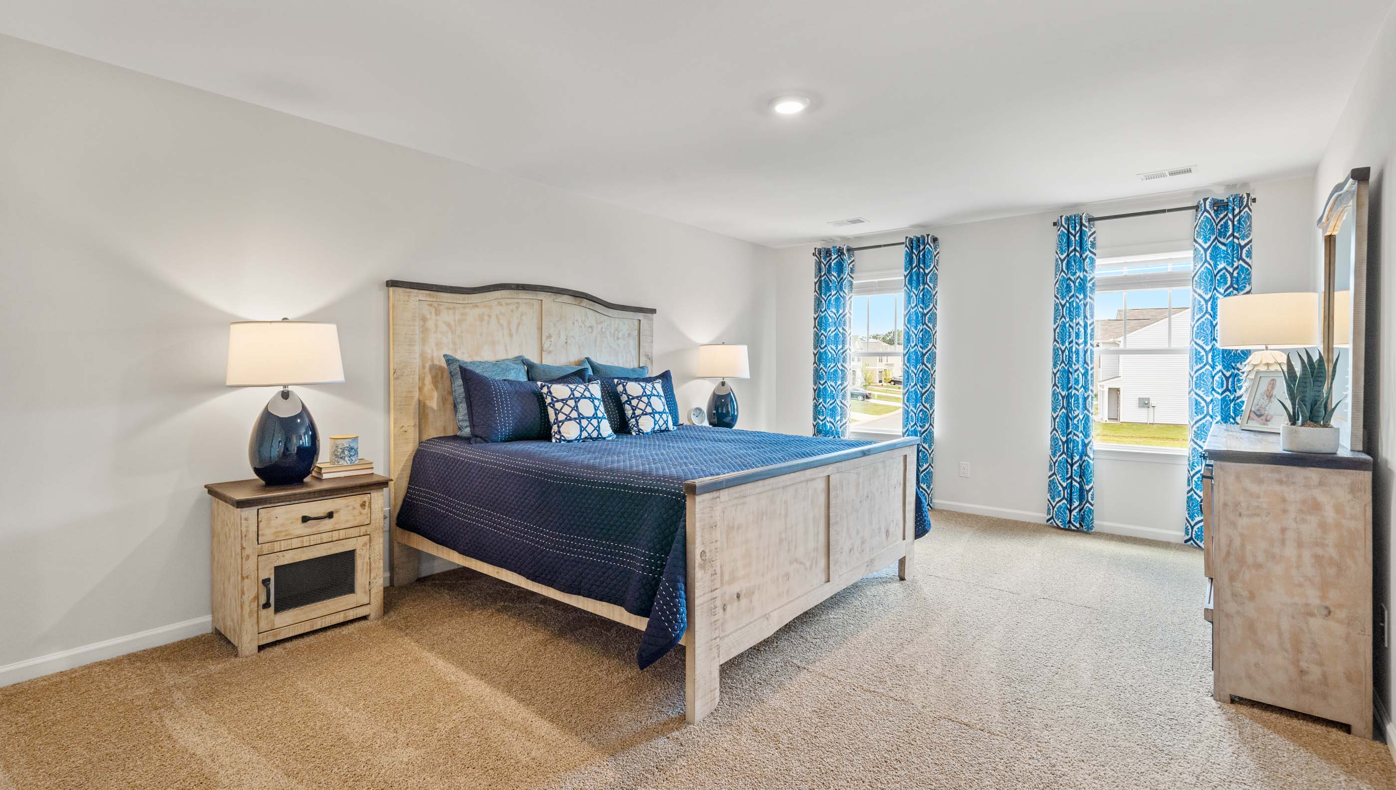 Primary bedroom with carpet floors and window.