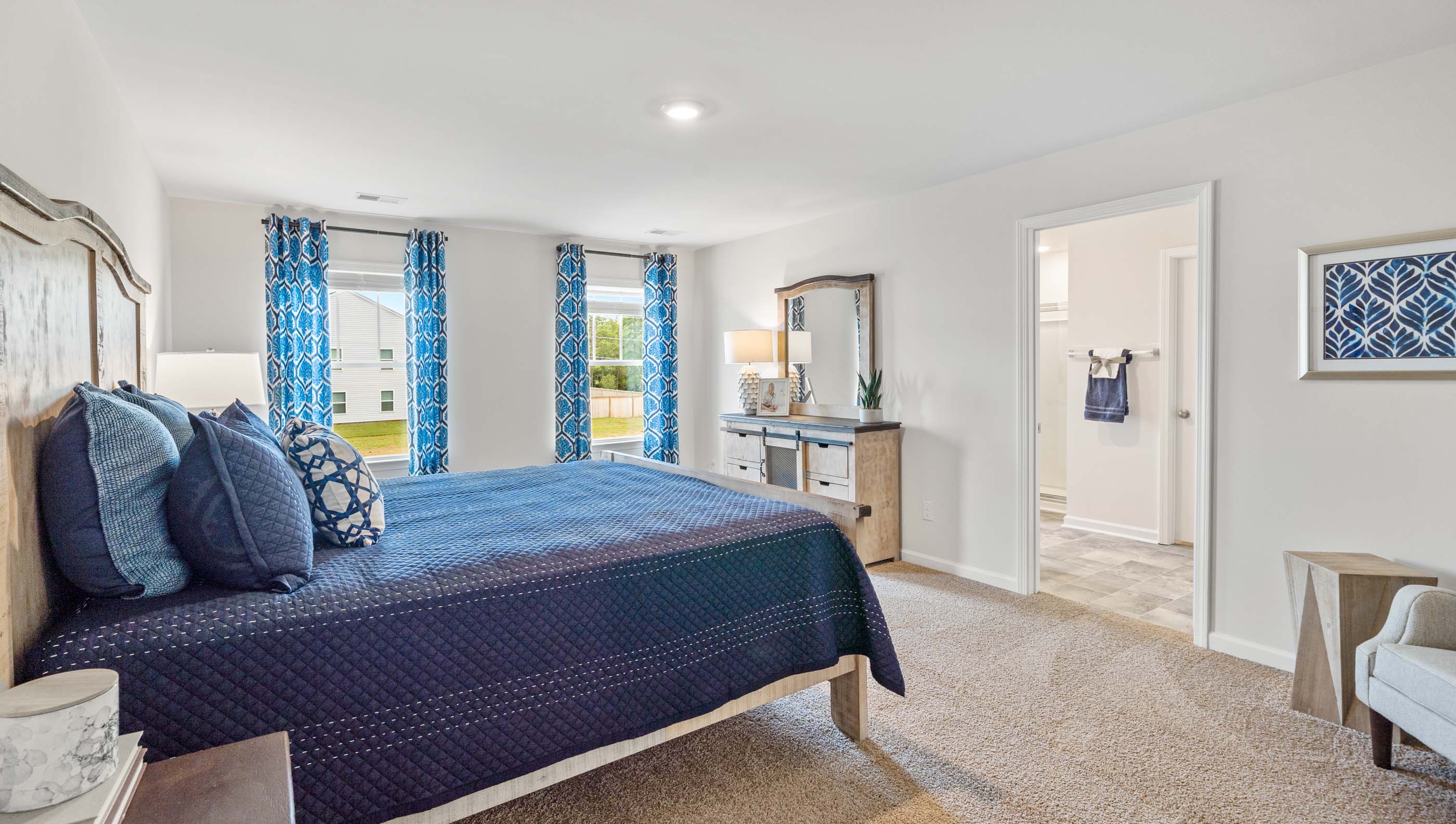 Primary bedroom with carpet floors and window.