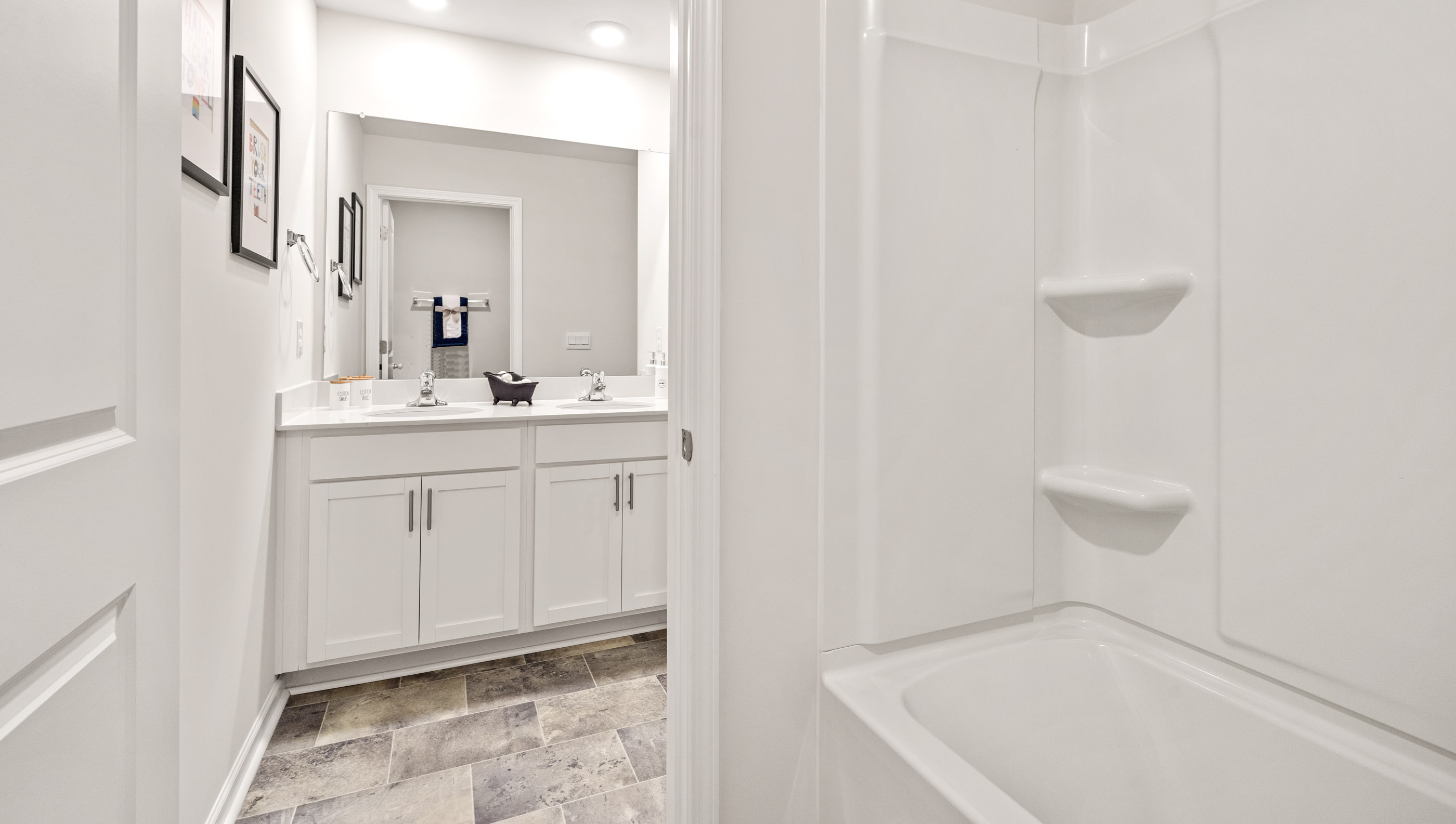 Double sink vanity and tub  in bathroom.