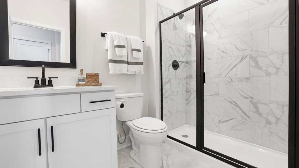 Bathroom with double vanity sink and walk in shower.