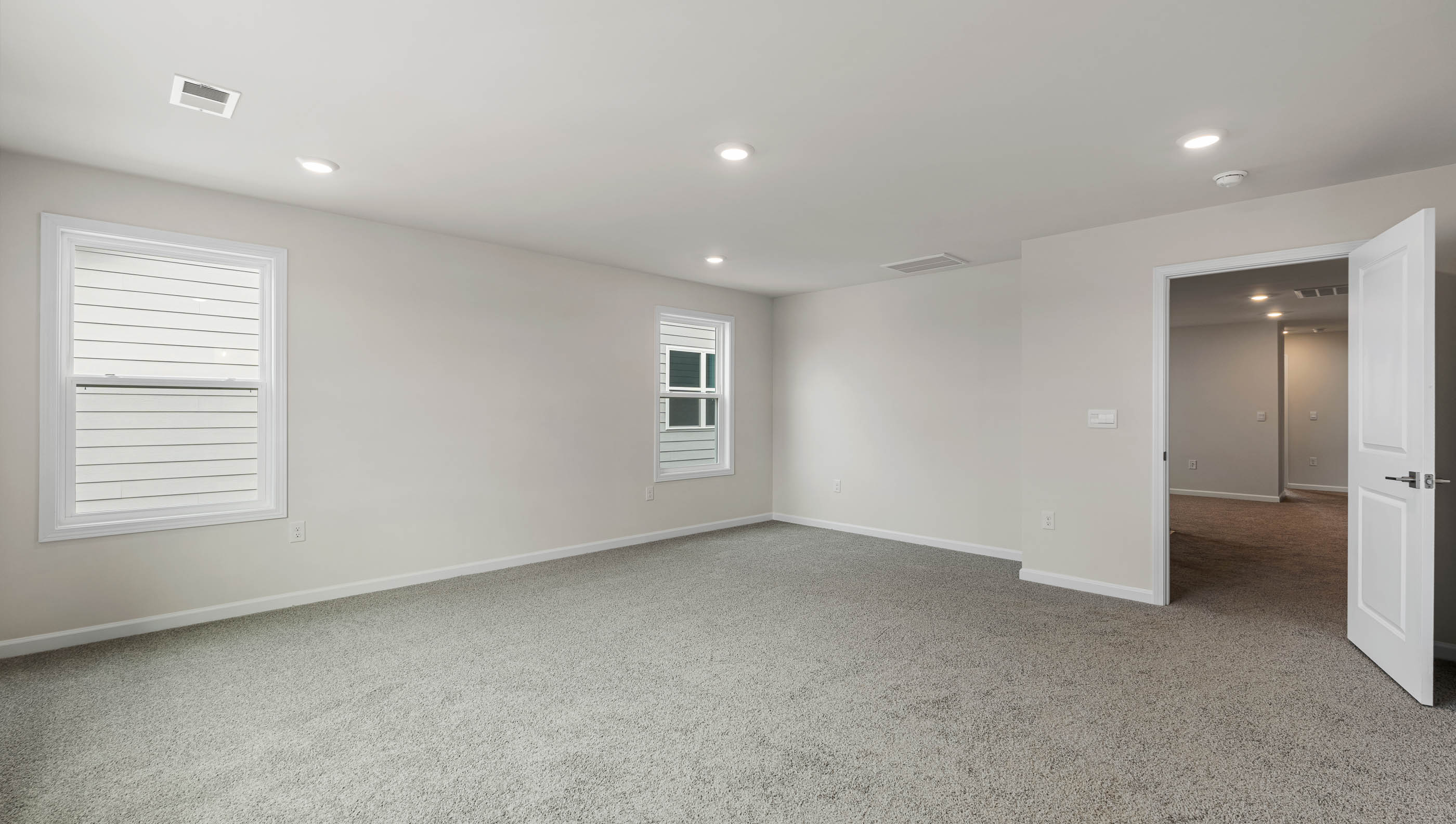 Bedroom with carpet and windows.