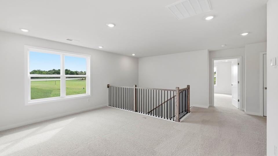 Loft area with carpet and windows.