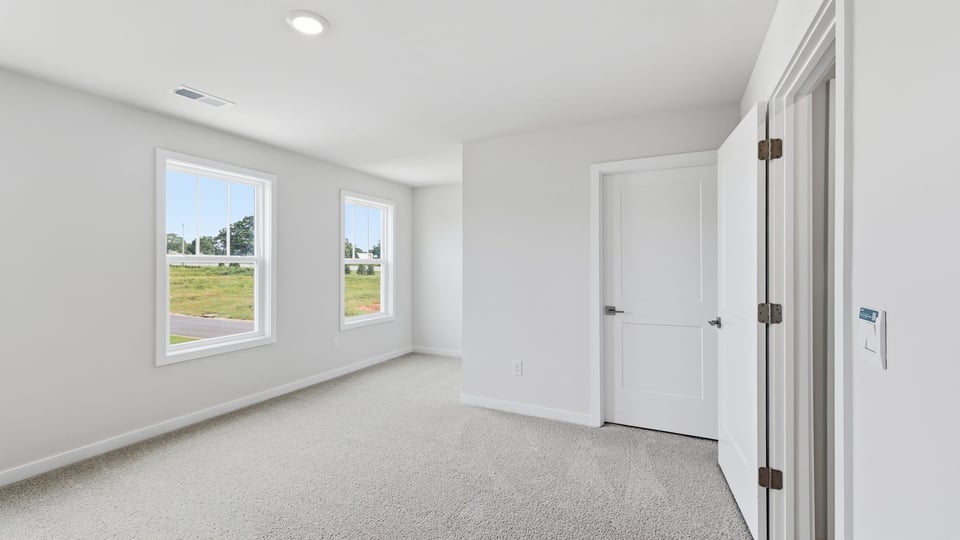 Bedroom with carpet and windows.