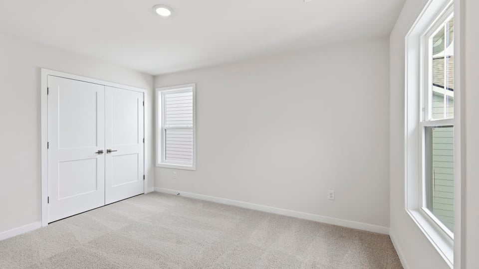 Bedroom with carpet and windows.