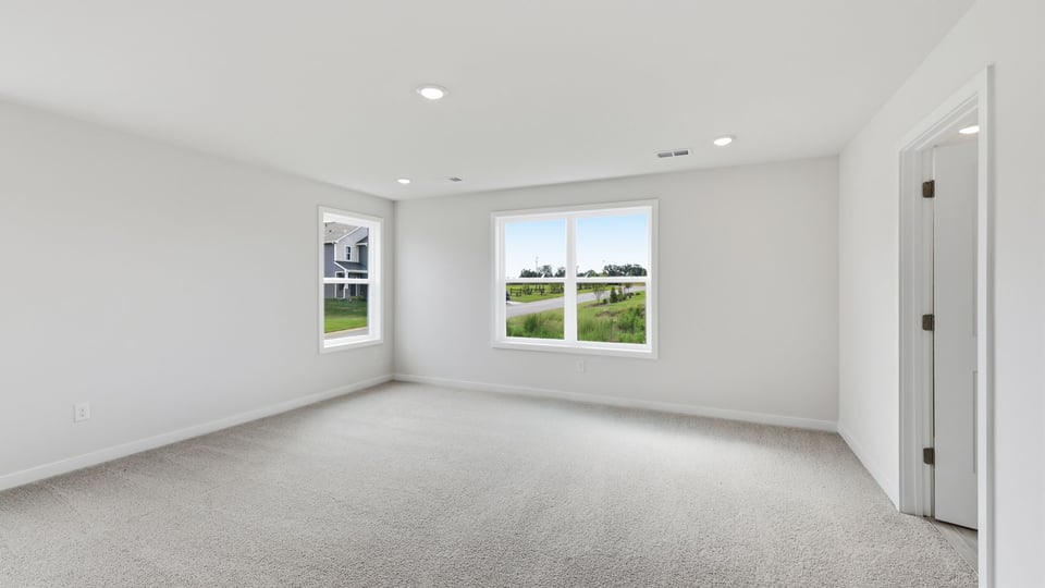 Bedroom with carpet and windows.
