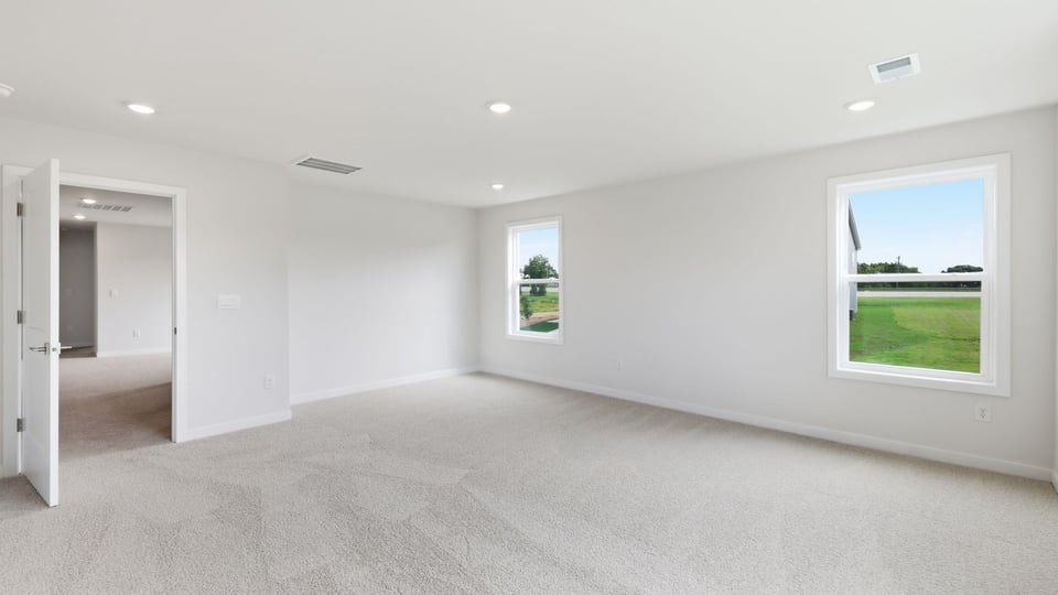 Bedroom with carpet and windows.