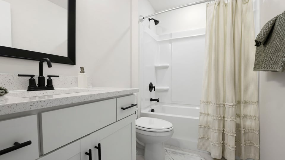 Bathroom with double vanity sink and shower.