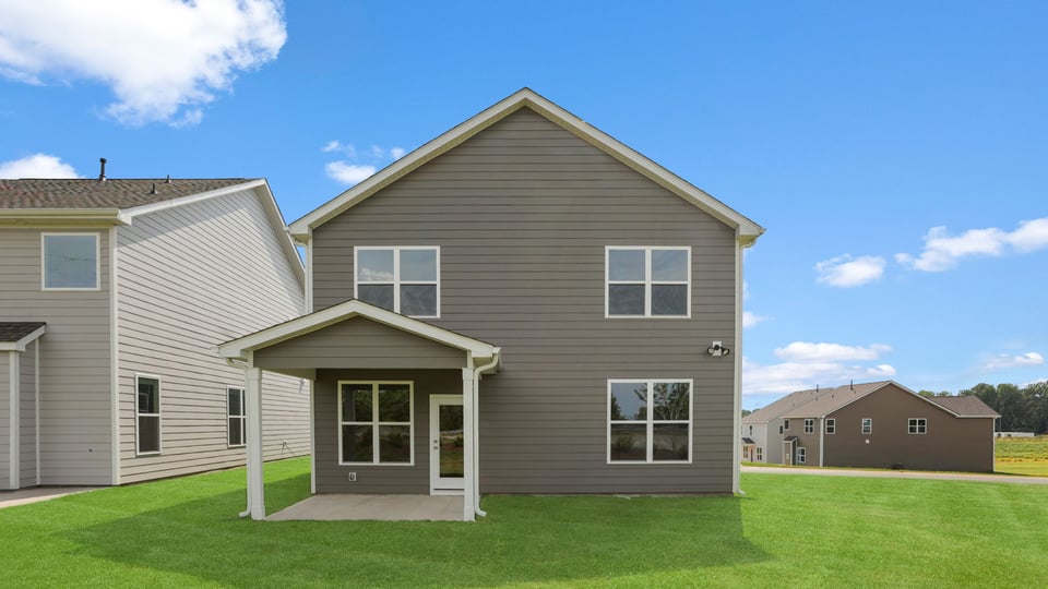Back exterior of home with large backyard.