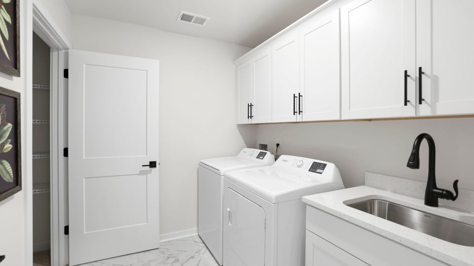 Laundry room with cabinets and sink.