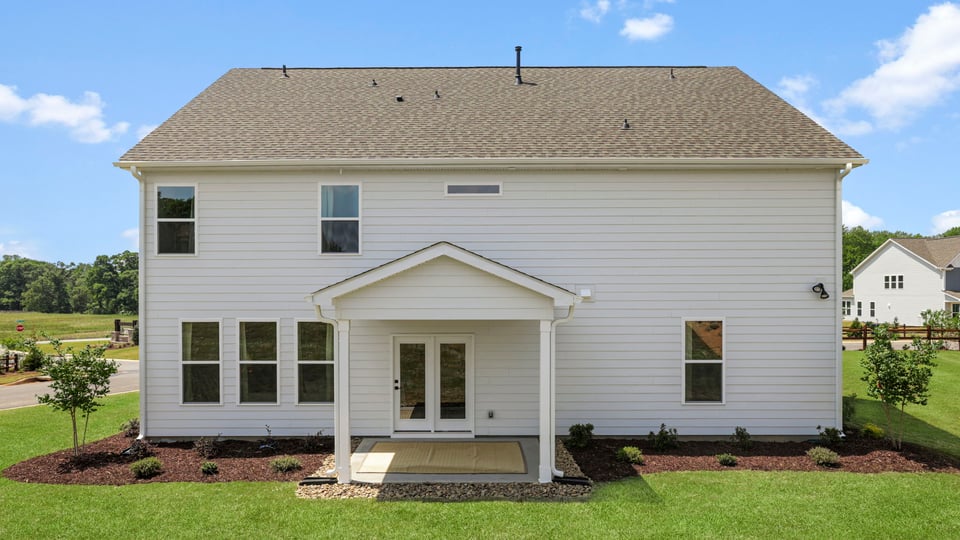 Back exterior of home with large backyard.