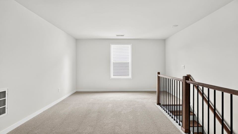 Loft area with carpet and window.