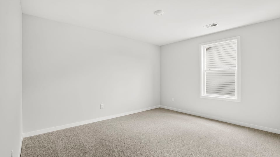 Bedroom upstairs with carpet and window.