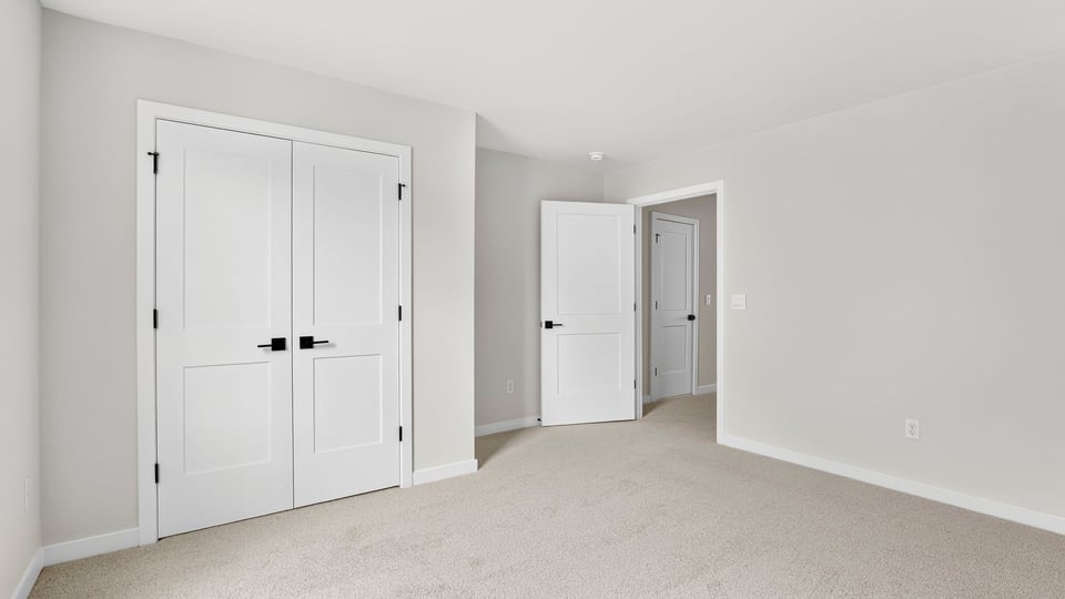 Bedroom upstairs with carpet and window.