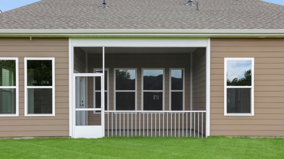 Back of home with covered patio.