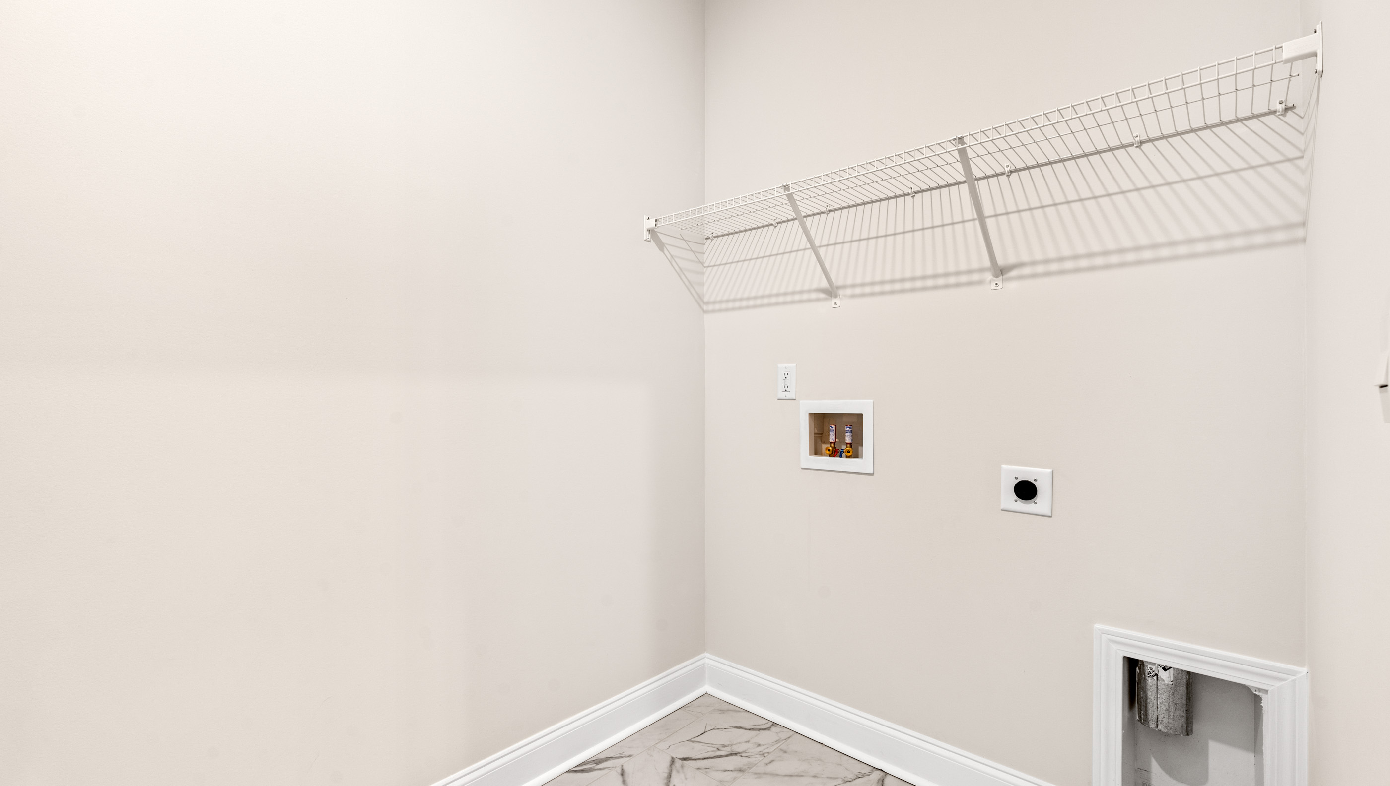 Walk in laundry with hanging shelves.