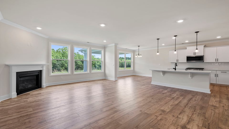 View of large family room with large windows and fireplace.