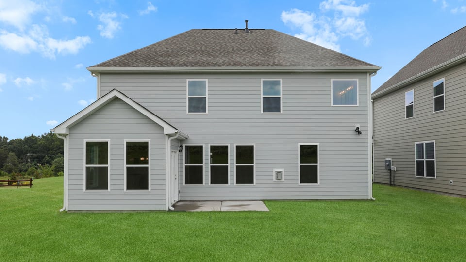 Back exterior of home with large backyard.
