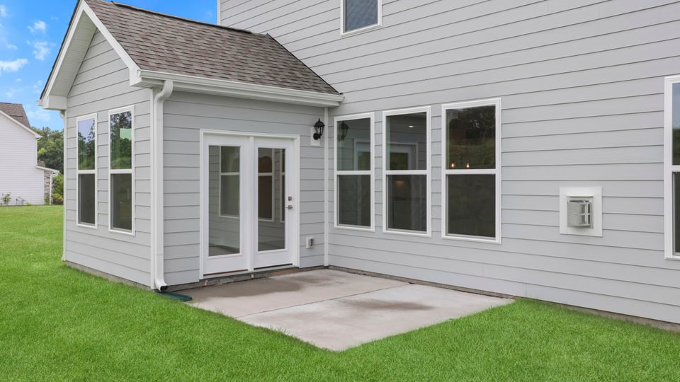 Back exterior of home with small patio.
