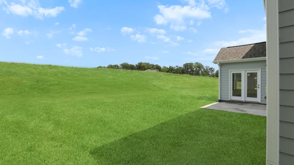 Back exterior of home with large backyard.