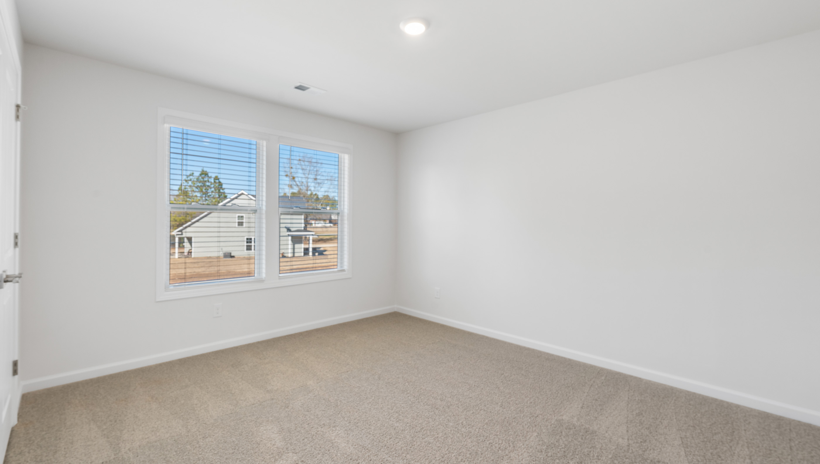 View of bedroom with large windows offering lots of natural light.