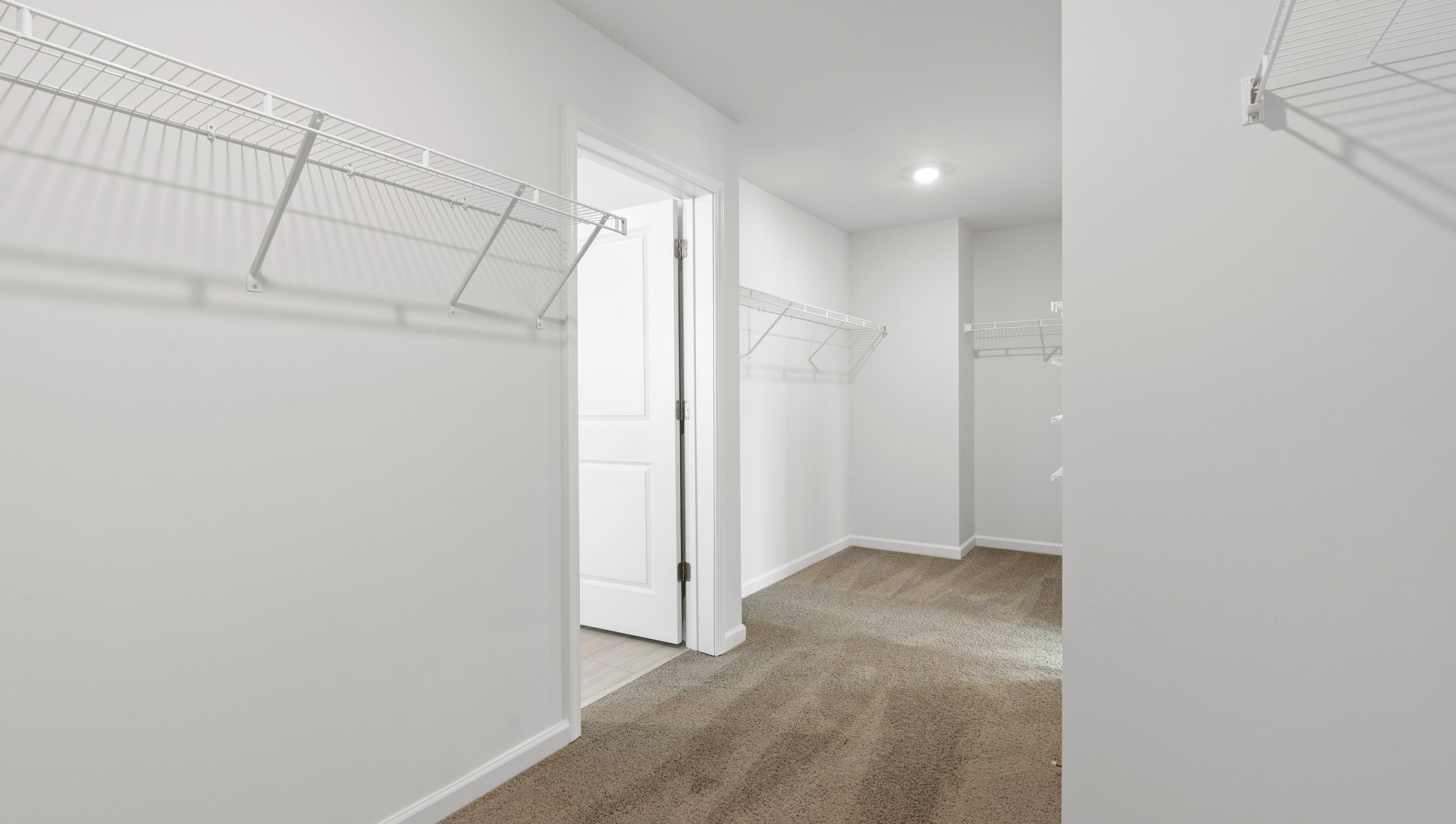 View of primary bedroom closet with his and hers closet hanging areas