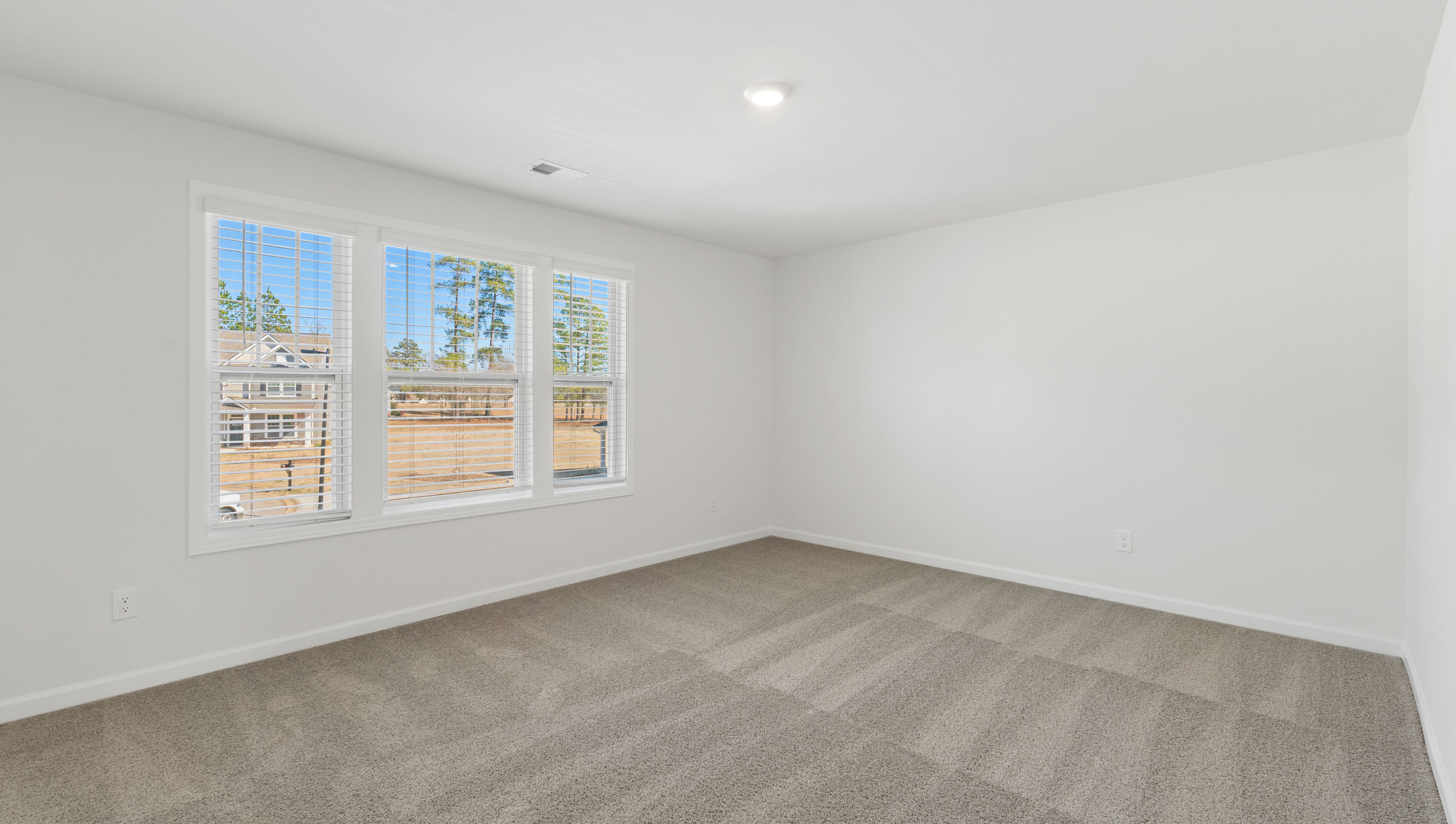 View of bedroom with large windows offering lots of natural light.