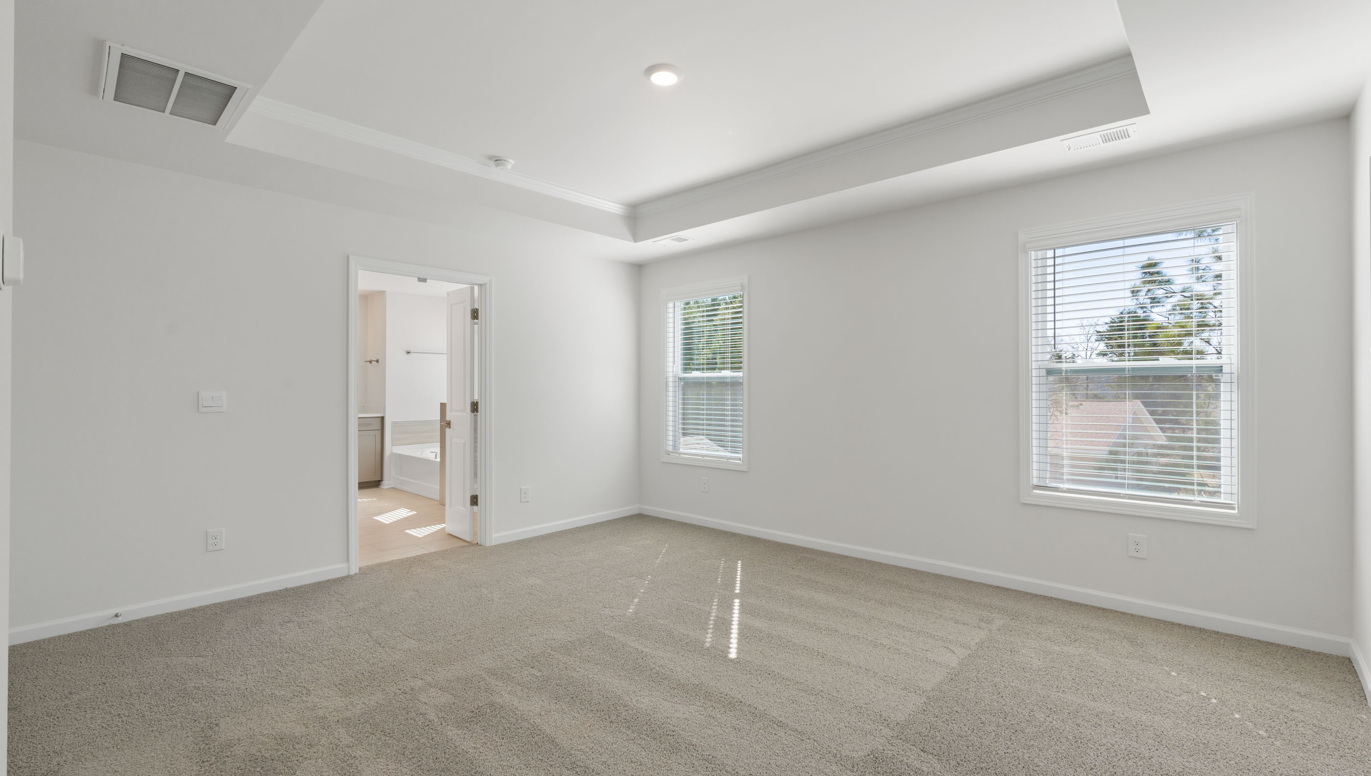 View of primary bedroom with large windows offering lots of natural light.