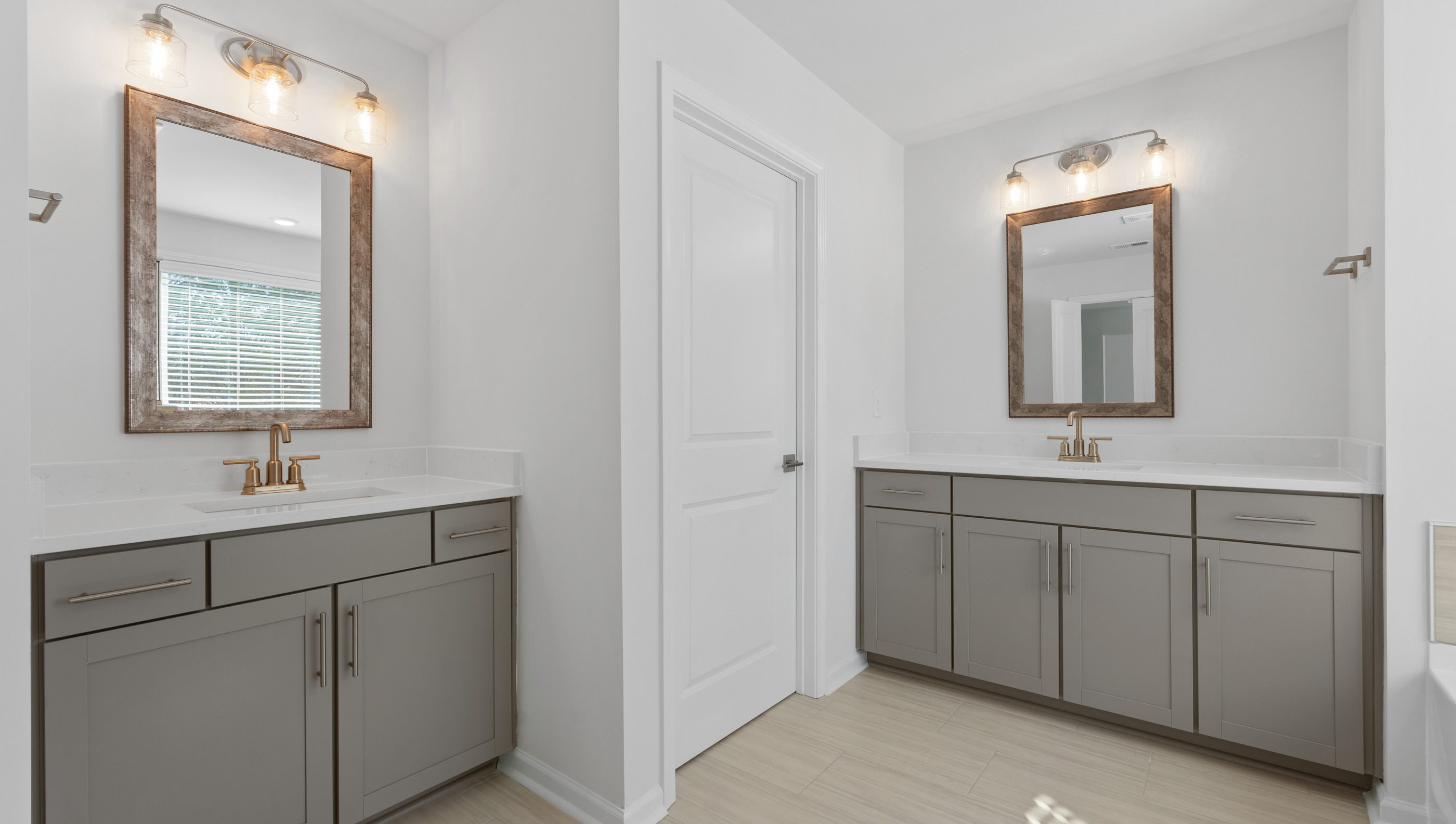 View of primary bathroom with dual vanities.