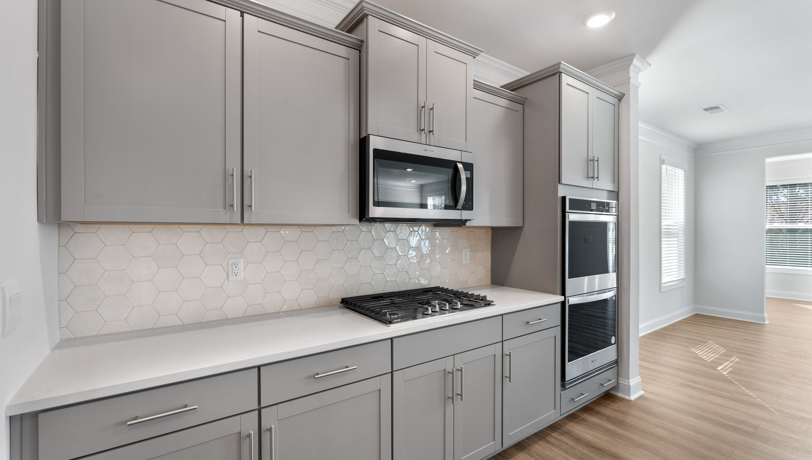 View of kitchen with quartz countertops and stainless steel appliances.