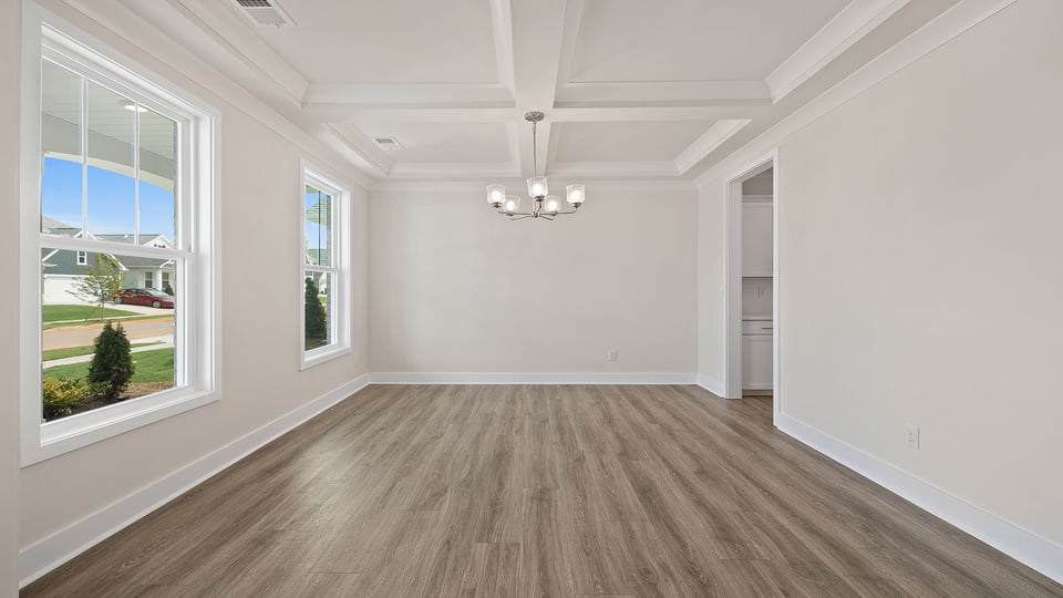 Dining room with chandelier and windows.