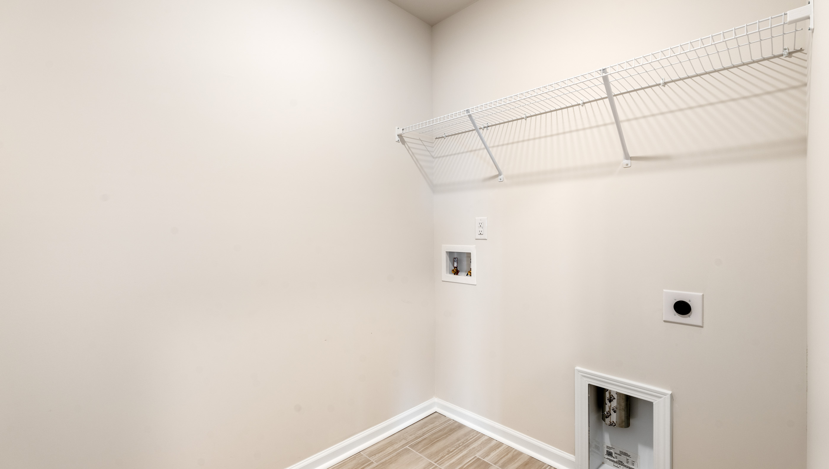 Walk in laundry with hanging shelves.