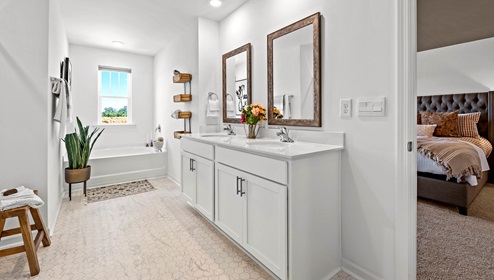 Primary bathroom with window and double sink vanity.