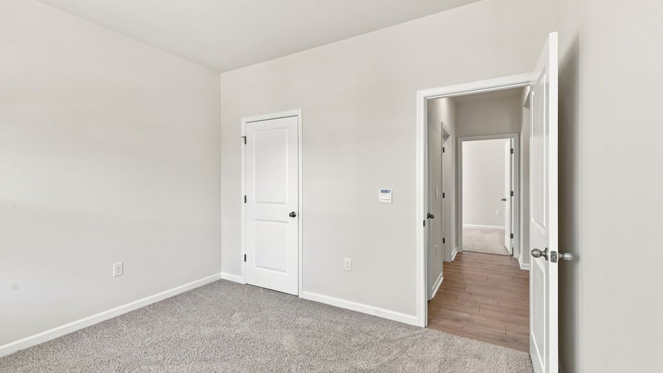 Bedroom with carpet and window.